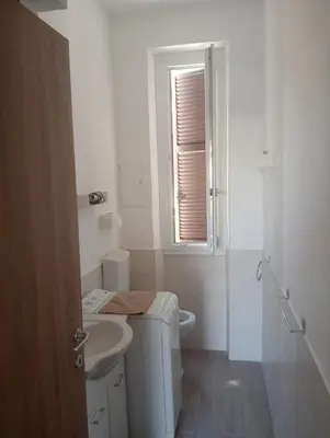 a white bathroom with a toilet and a sink at Danielas House in Rome