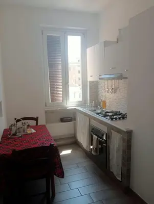a kitchen with a table and a stove and a window at Danielas House in Rome