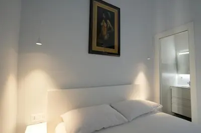 a white bedroom with a bed and a picture on the wall at Camera con bagno in posizione strategica in Rome