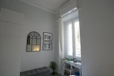 a white living room with a couch and a window at Camera con bagno in posizione strategica in Rome