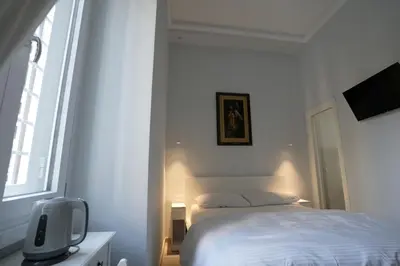 a white bedroom with a bed and a tv at Camera con bagno in posizione strategica in Rome