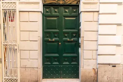 a green door on a building with a gate at LUXURY BABUINO -exclusive apartment in Rome