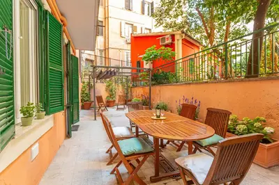 a patio with a wooden table and chairs on a balcony at Vatican Museums Stay with Terrace in Rome