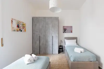 a bedroom with two beds and a wardrobe at Macedonia 30 Bright Flat in Rome