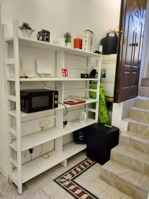 a room with white shelves with a microwave and a staircase at Vatican room - all you need to sleep 1 in Rome