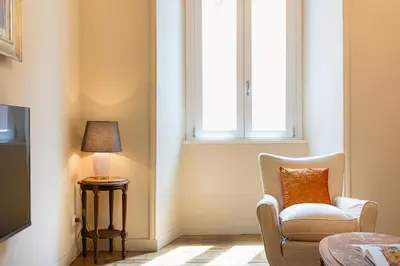 a living room with a chair and a lamp at Amazing 3 Bedrooms Prati Vatican in Rome