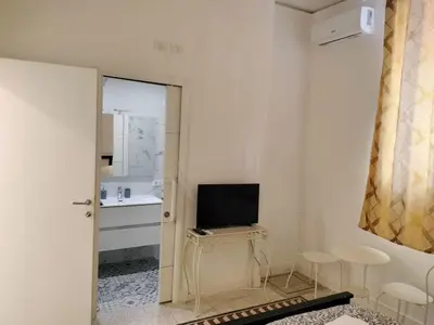 a white room with a television and a table with chairs at Vatican Room -all you need to sleep 2 in Rome
