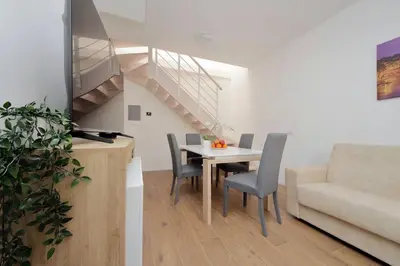 a dining room with a table and chairs and a staircase at Sabelli 2 Villa Indipendente nel Cuore di Roma in Rome