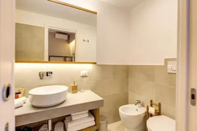 a bathroom with a sink and a toilet and a mirror at The Spanish Suite Campo de' Fiori in Rome
