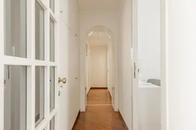a hallway with white walls and an arched doorway at La Dolce Vita - Elegant retreat in the heart of Rome in Rome