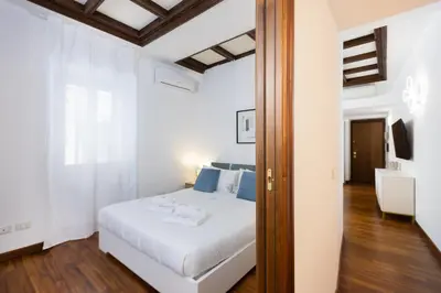 a bedroom with a white bed and a mirror at Vicolo Trevi Apartment by Rental in Rome in Rome