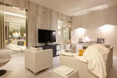 a living room with white furniture and a flat screen tv at Saphir Luxury Apartment in Rome