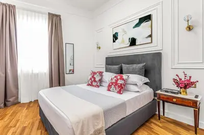 a bedroom with a bed with red and white pillows at Blue Prestige Suites in Rome