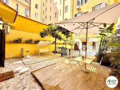 a patio with an umbrella and a table and chairs at Colosseo - Venus House in Rome