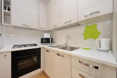 a kitchen with white cabinets and a sink at 4BNB - Porta Portese Cozy Apartment in Rome