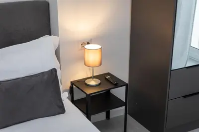 a lamp on a night stand next to a bed at Constance Terrace Apartment by Rental in Rome in Rome
