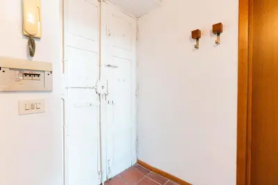 a kitchen with white walls and a door at Domus Sabelli in Rome