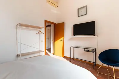 a bedroom with a bed and a tv and a chair at Domus Sabelli in Rome