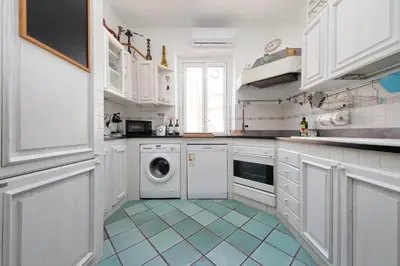 a kitchen with white cabinets and a washing machine at Giuliana in Rome