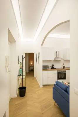 a living room with a blue couch and a kitchen at Nomentana Home in Rome