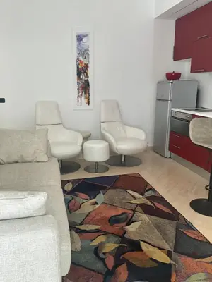 a living room with a couch and two chairs and a rug at Appartamento Porto di Ripetta in Rome