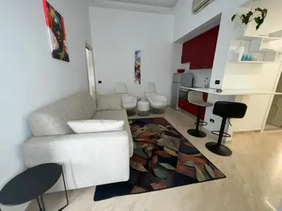 a living room with a white couch and a rug at Appartamento Porto di Ripetta in Rome