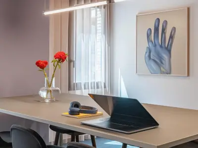 a desk with a laptop and a hand on the wall at Numa Rome Trastevere in Rome