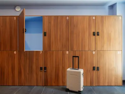 a suitcase sits in front of a row of lockers at Numa Rome Trastevere in Rome