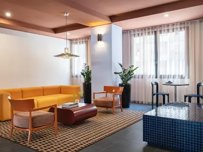 a living room with a yellow couch and chairs at Numa Rome Trastevere in Rome