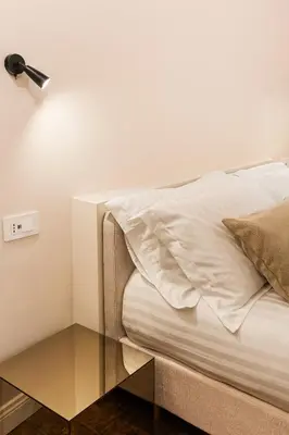a bed with a glass side table next to it at the secret terrace - navona in Rome