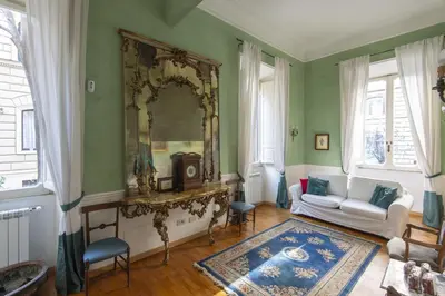 a living room with a white couch and a mirror at Vatican Luxury Three Bedroom Apartment in Rome