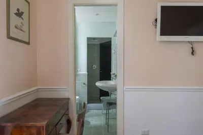a bathroom with a sink and a television on a wall at Vatican Luxury Three Bedroom Apartment in Rome