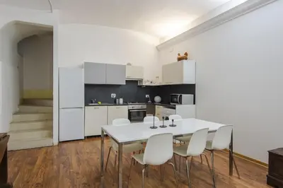 a kitchen with a white table and white chairs at Vatican Luxury Three Bedroom Apartment in Rome