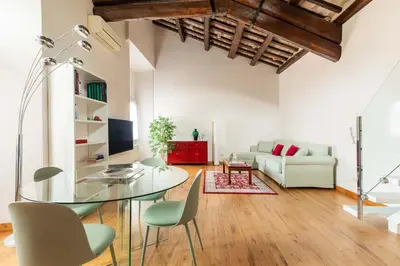 a living room with a glass table and chairs at Pantheon Palace Loft by RomeLoft in Rome