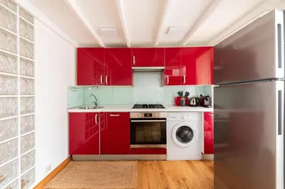 a kitchen with red cabinets and a washer and dryer at Pantheon Palace Loft by RomeLoft in Rome