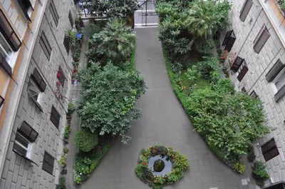 an internal courtyard of a building with plants and trees at Karina Suite in Rome