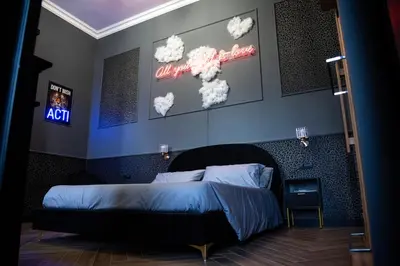 a bedroom with a bed and signs on the wall at One of one Experiences - LOVE SPA SUITE in Rome