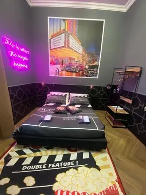 a bed in a room with a poster on the wall at One of one Experiences - CINEMA ROOM in Rome