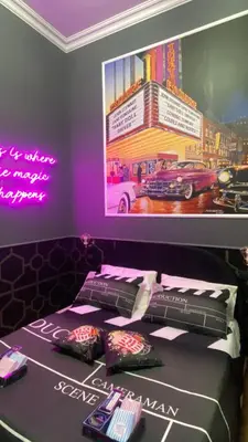 a bed with pillows and a poster on the wall at One of one Experiences - CINEMA ROOM in Rome