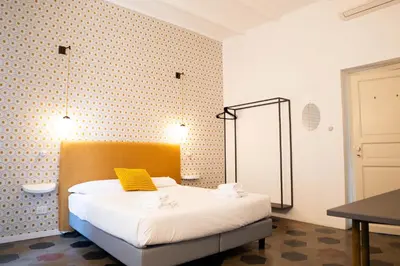 a bedroom with a bed with a yellow pillow on it at 101 Flats Candia's Suites in Rome