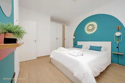 a bedroom with a white bed with a blue wall at Color House, roof garden & parking in Rome