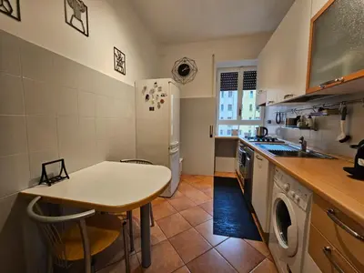 a kitchen with a white table and a refrigerator at Be Your Home - Giulio's Apartment in Rome