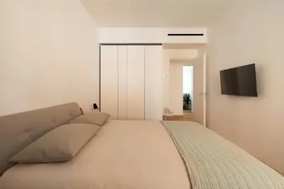 a bedroom with a bed with a television on the wall at Popolo Design Apartment by RomeLoft in Rome