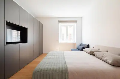 a living room with a bed and a television at Popolo Design Apartment by RomeLoft in Rome