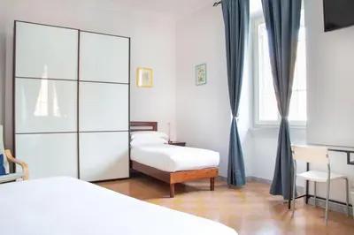 a bedroom with two twin beds and a dresser at Dimora Romana - Vintage Elegance and Modern Comfort in Rome