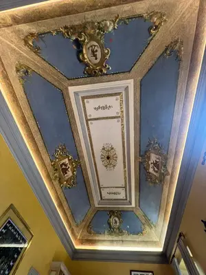 a coffered ceiling with golditures on it at Antico Suites Roma in Rome