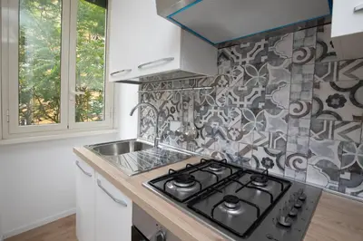 a kitchen with a stove and a sink at Civico Appia Apartment in Rome