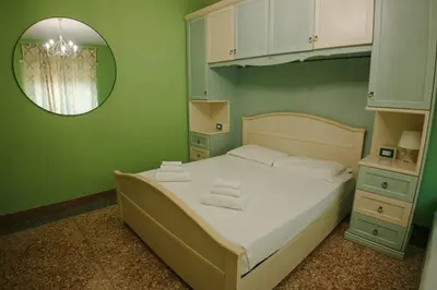 a green bedroom with a bed and a mirror at Appartamenti Romolo E Remo in Rome