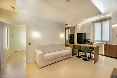 a living room with a couch and a table and a kitchen at Borghese Boutique in Rome