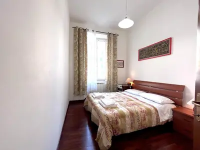 a bedroom with a large bed with blue and white sheets at DomusVaticano in Rome